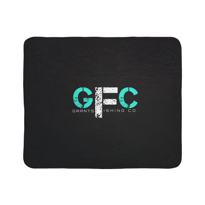 Black blanket with teal and white logo on a white background