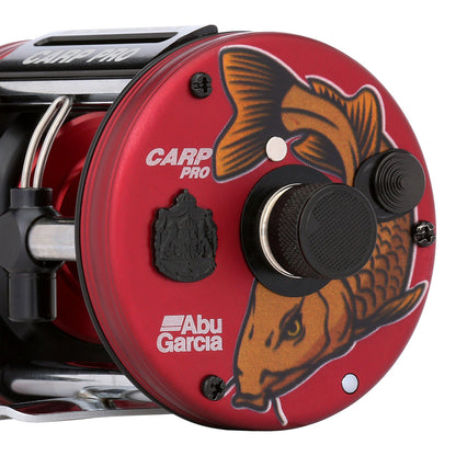 Red Abu Garcia Carp Pro fishing reel with fish design on a white background