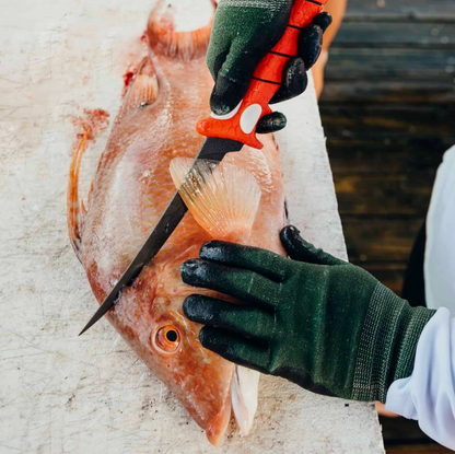 Person filleting a fish with a knife on a concrete surface