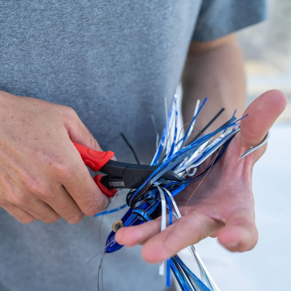 Person cutting blue fishing line with scissors