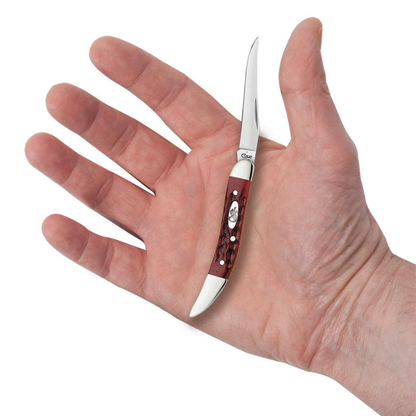 Small knife with a red handle held in a hand against a white background