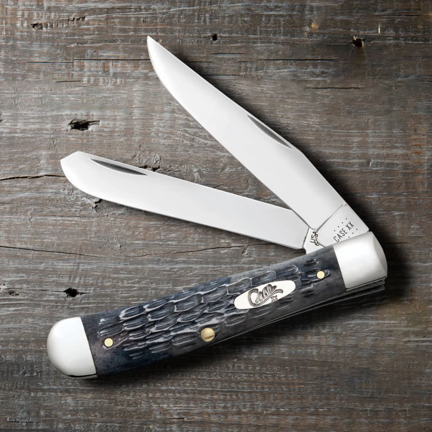 Trapper knife with a dark handle on a wooden surface