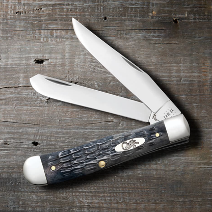 Trapper knife with a dark handle on a wooden surface