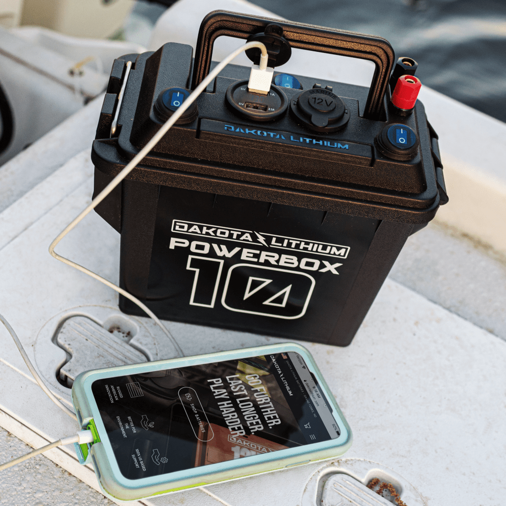 Dakota Lithium Powerbox 10A battery on a boat with a phone connected, showing music app.