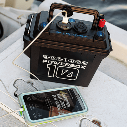 Dakota Lithium Powerbox 10A battery on a boat with a phone connected, showing music app.