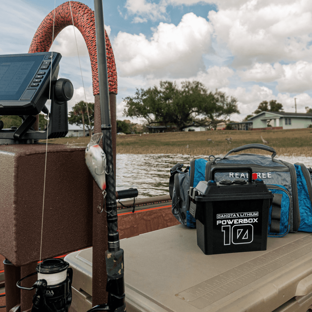Fishing setup on a boat with a powerbox, fishing rod, and tackle box.