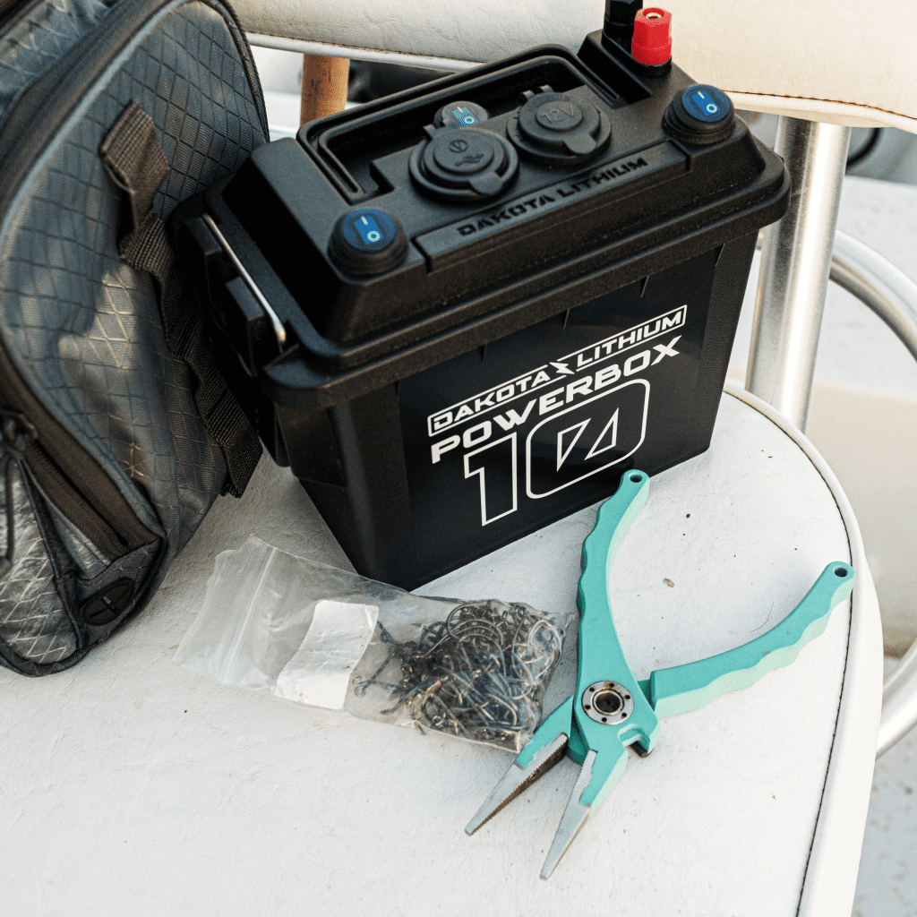 Dakota Lithium Powerbox 10 battery on a white surface with pliers and tools.