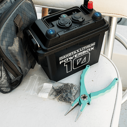 Dakota Lithium Powerbox 10 battery on a white surface with pliers and tools.