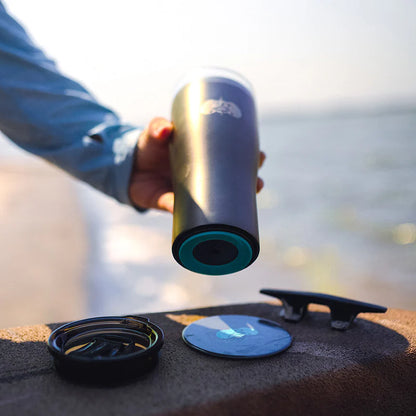 Person holding a insulated mug with a scenic background
