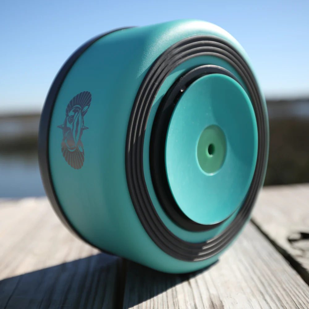 Turquoise wheel with black rim on a wooden surface