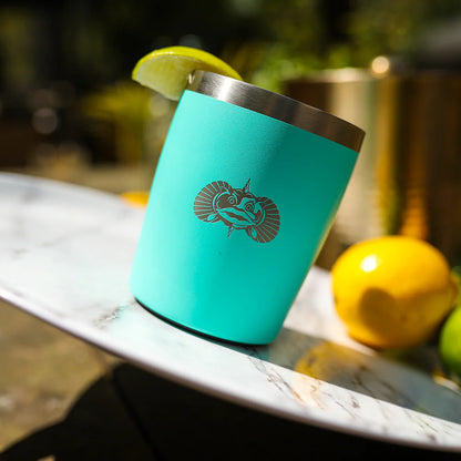 Turquoise insulated cup with a logo on a marble surface with lemons in the background