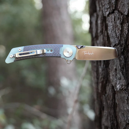 Folding knife with a wooden handle attached to a tree in a forest setting