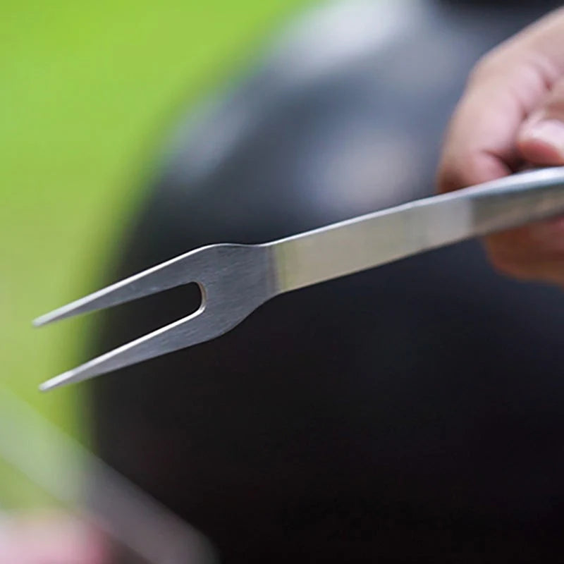 Metallic fork held by a hand with a blurred background