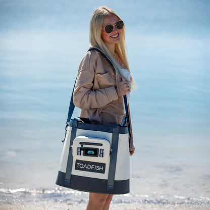 Woman holding a TOADFISH cooler bag on a beach